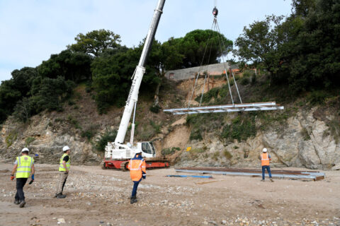 Une grue chenille lève la passerelle qui va assurer la continuité du chemin côtier à Trébézy ce jeudi 18 septembre.